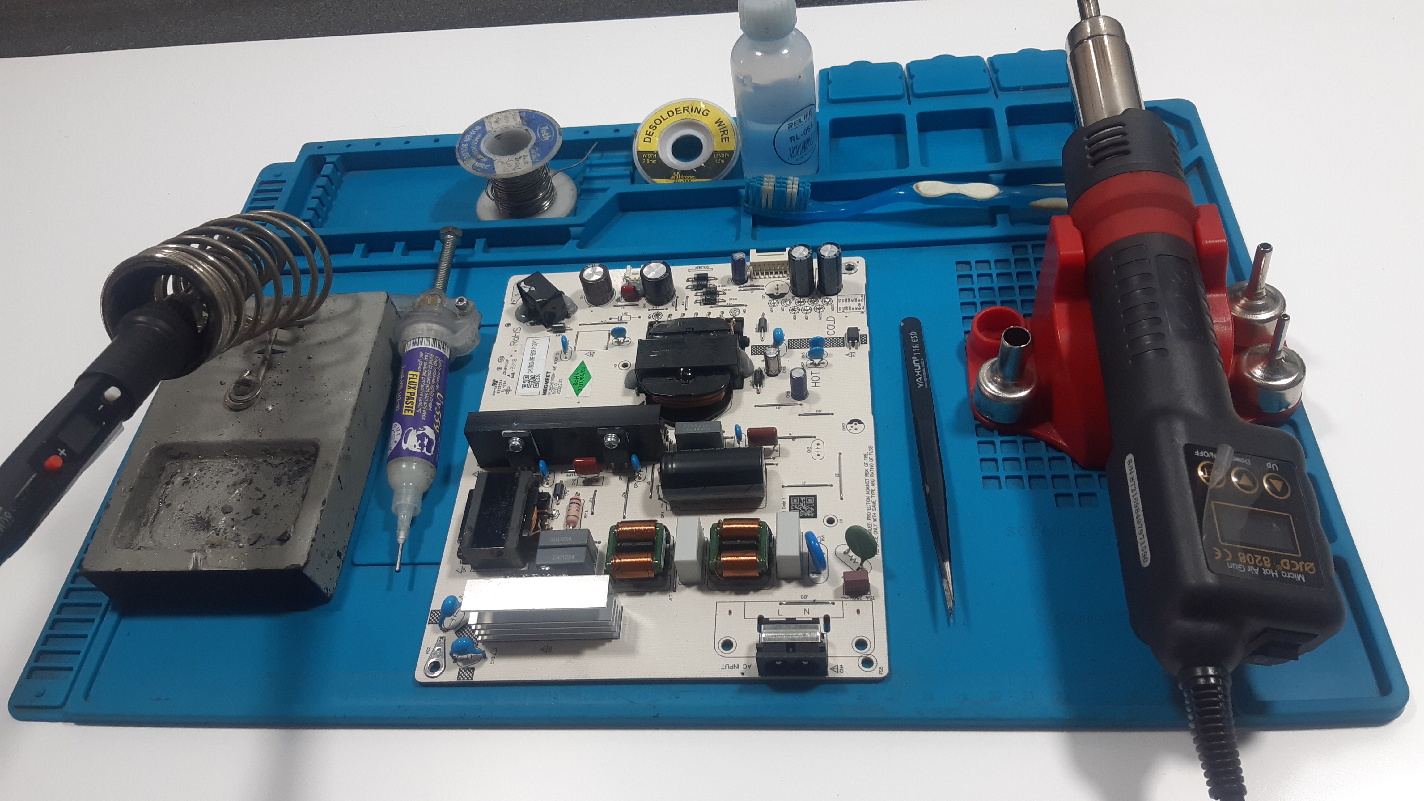 Placa de fuente de poder de un televisor sobre un banco de trabajo técnico